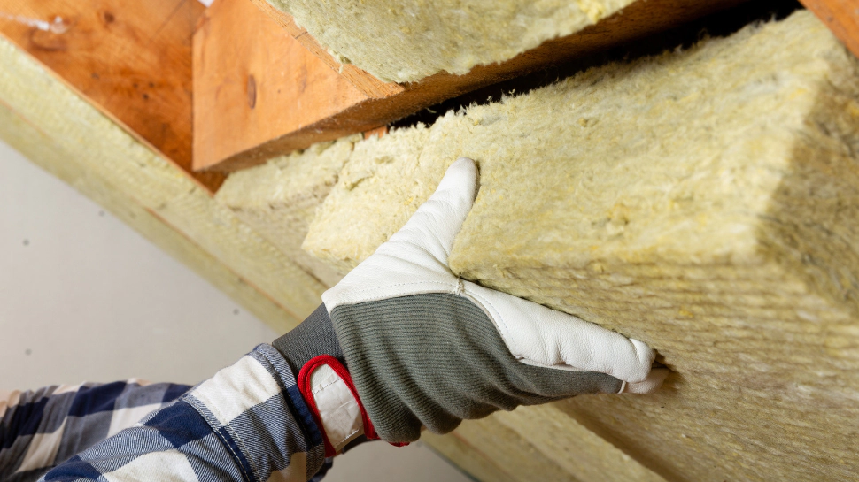 a hand installing a dense packing insulation